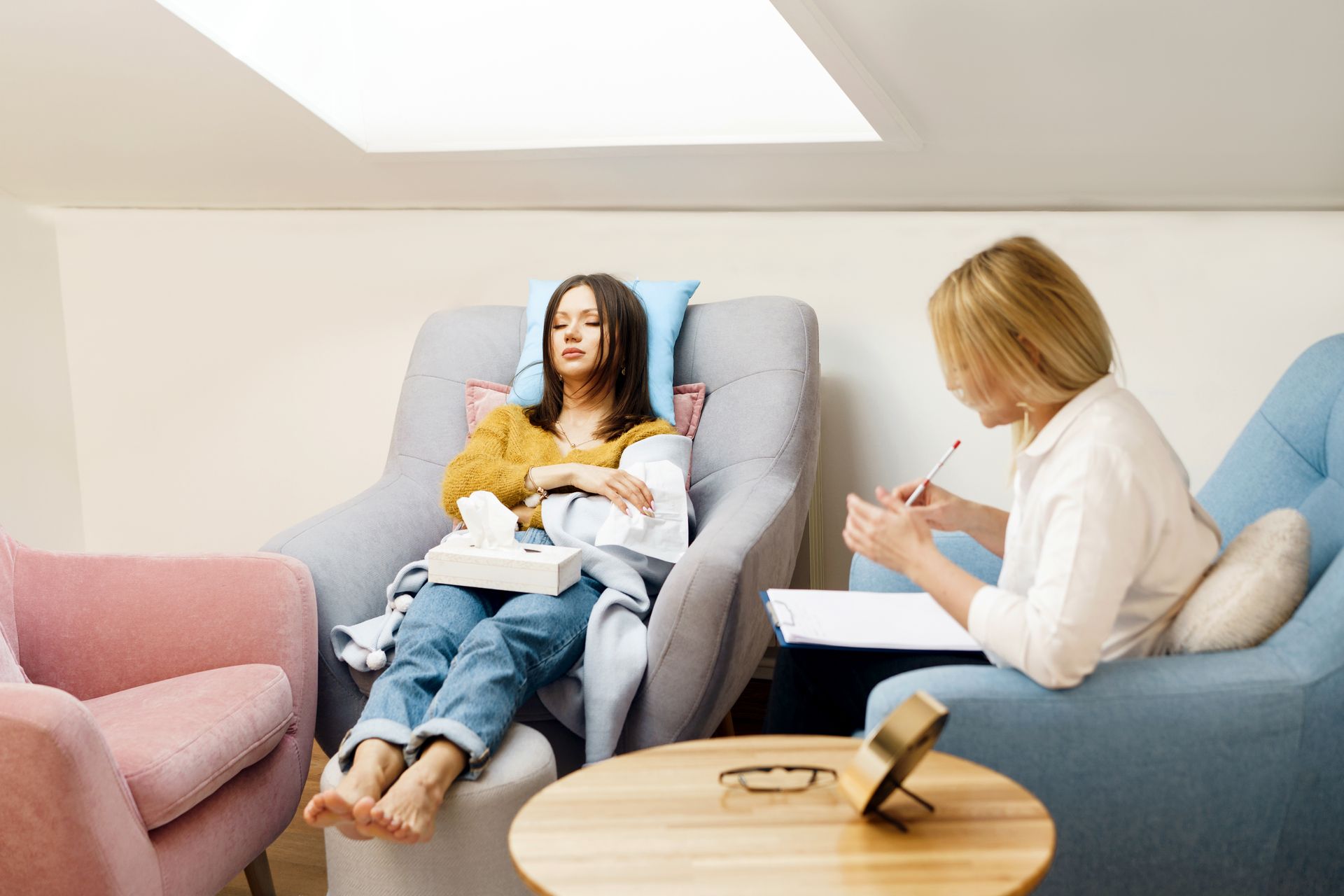 A woman is laying in a chair talking to a therapist.