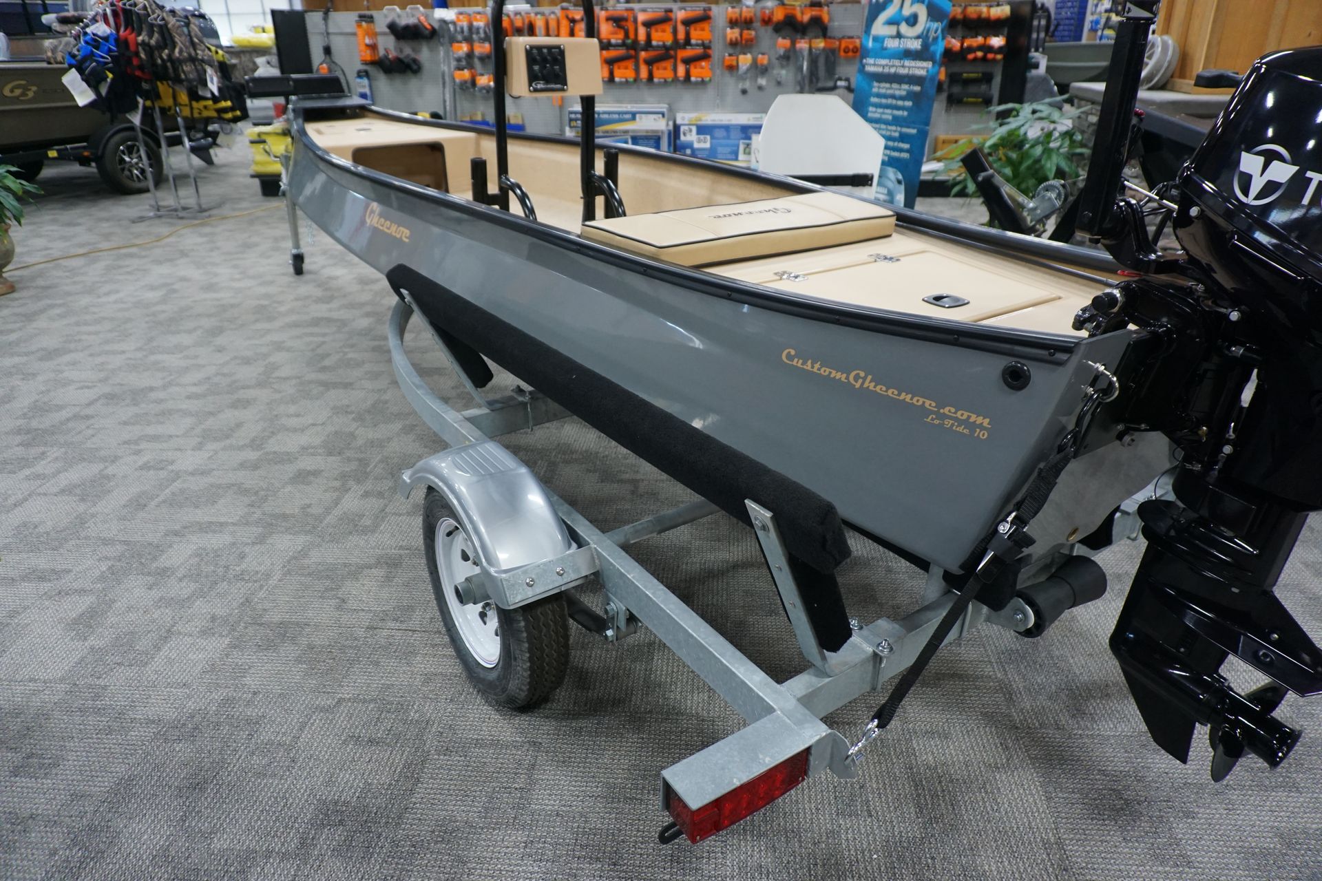 A small boat is on a trailer in a store.