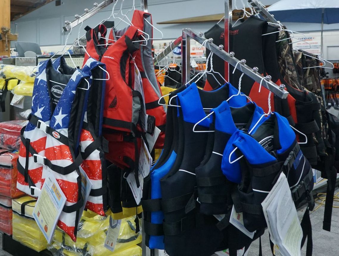 A bunch of life vests are hanging on a rack