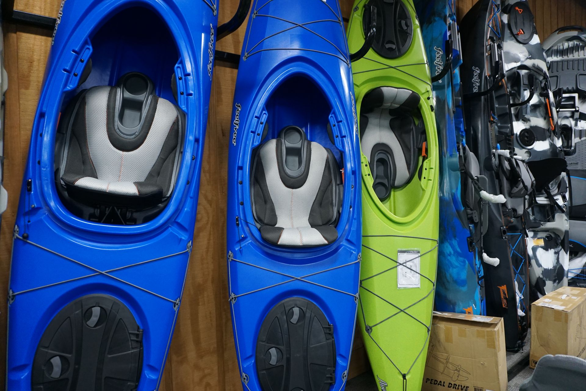 A row of blue and green kayaks hanging on a wall.