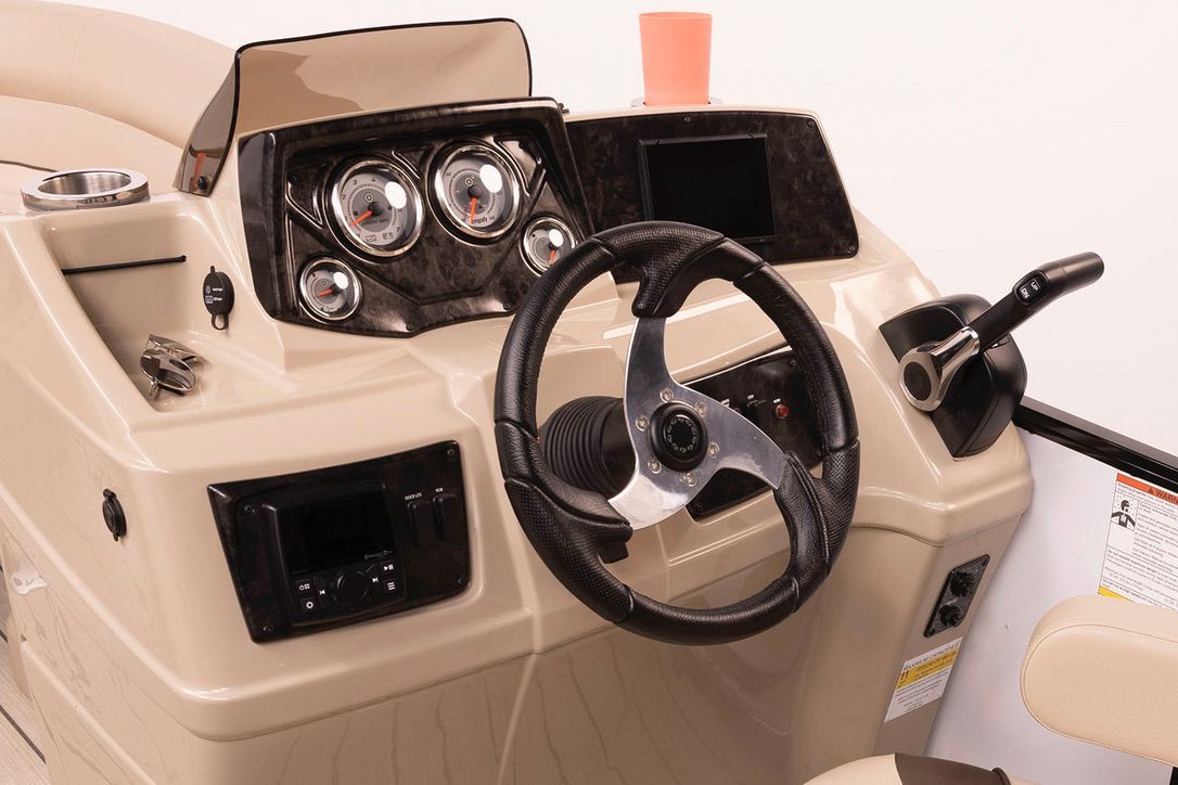 A close up of a boat 's steering wheel and dashboard.