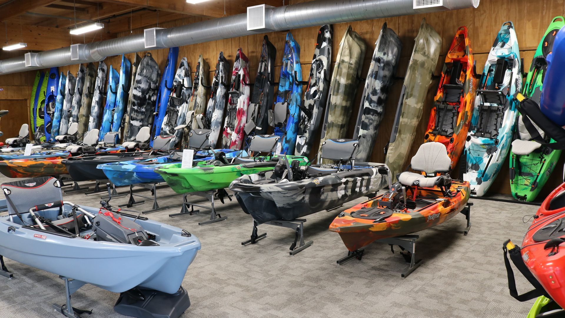 There are many different types of kayaks in this room.