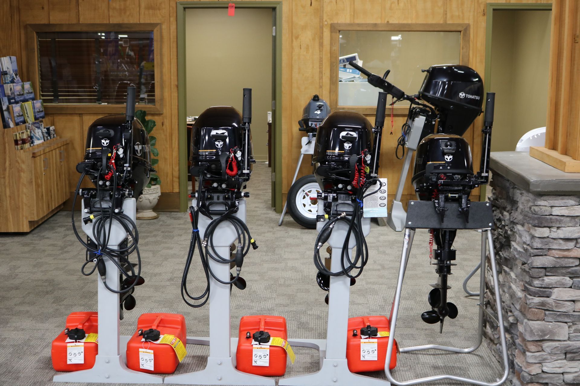 A row of outboard motors are lined up in a room.