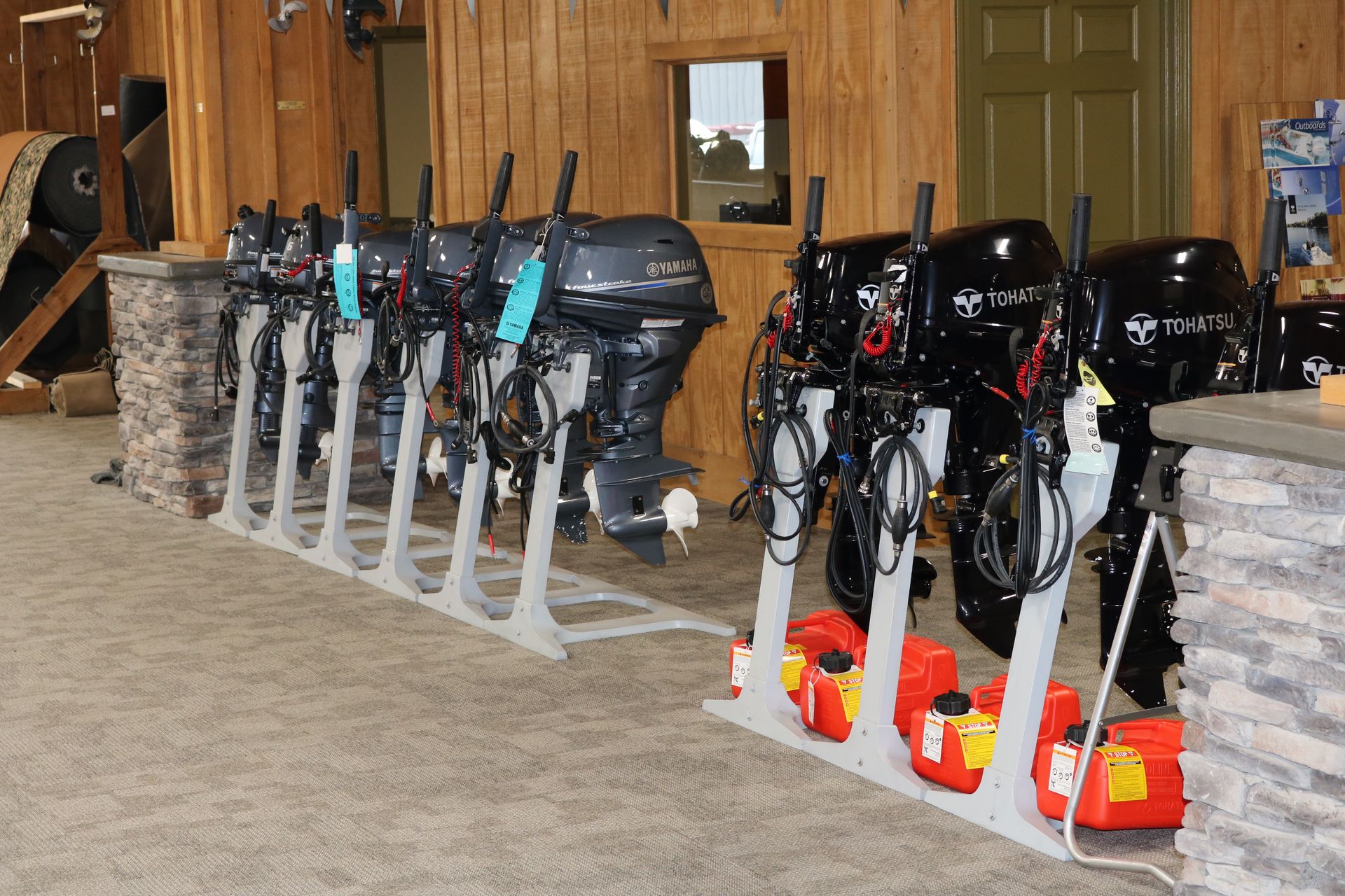 A row of outboard motors are lined up in a showroom.