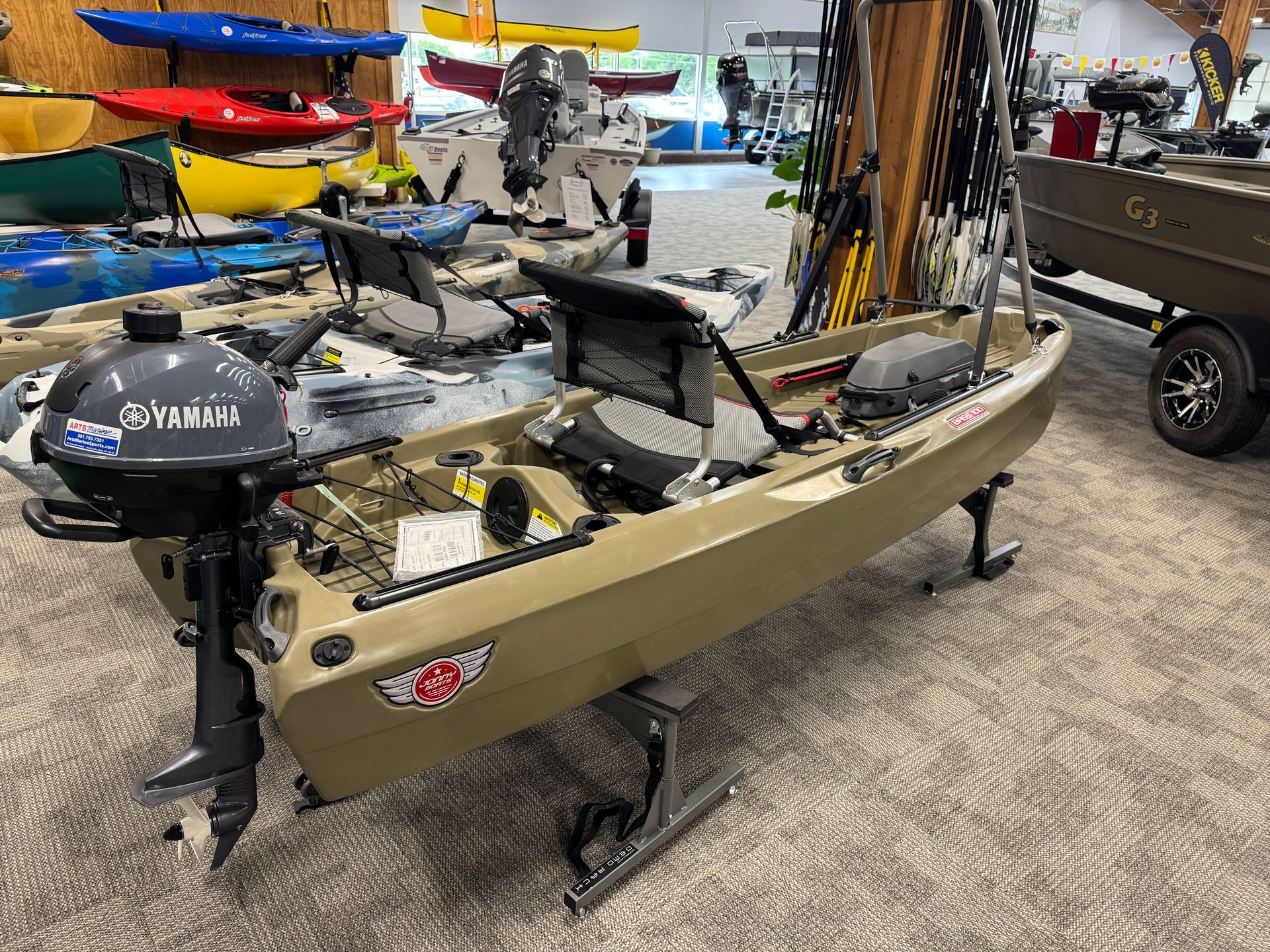 A kayak is sitting on top of a carpet next to other kayaks.