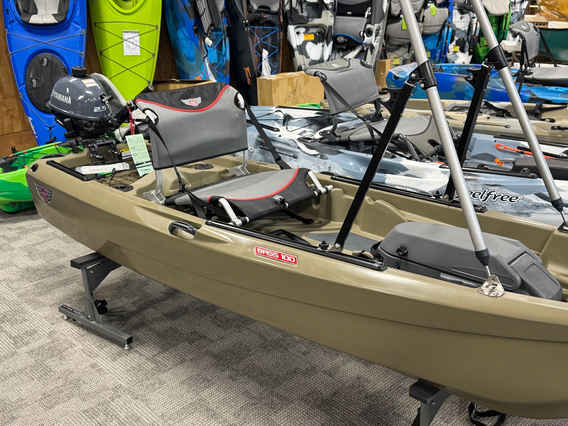 A kayak is sitting on top of a carpet next to other kayaks.