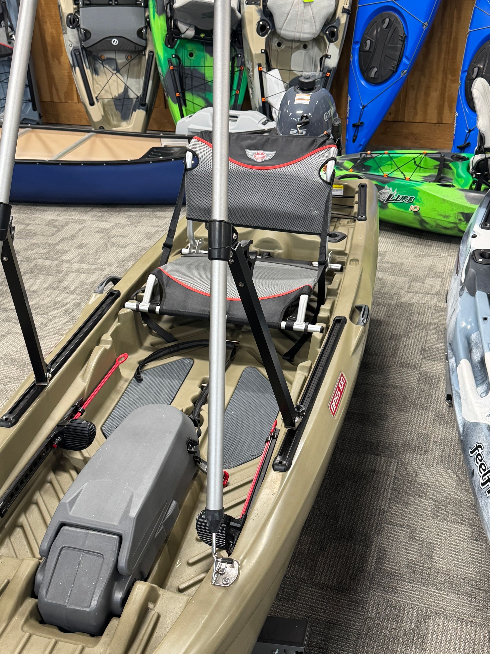 A kayak with a motor attached to it is sitting in a showroom.