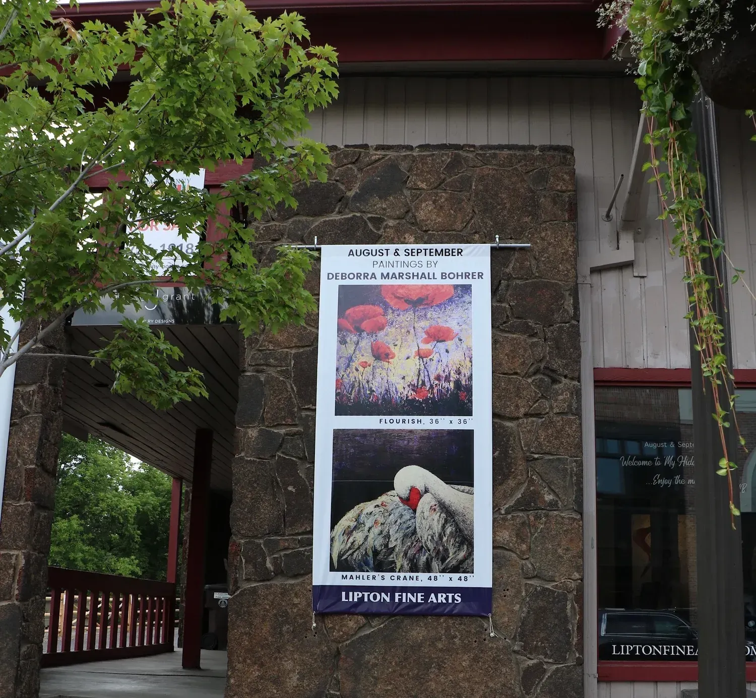 Banner advertising art exhibition with red flowers and bird.