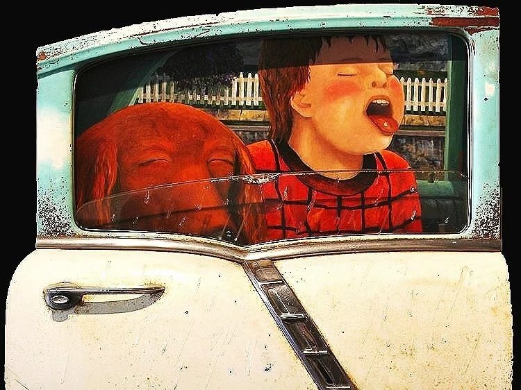 Boy and dog sticking tongues out of a vintage car window; red plaid shirt, aqua and white car.
