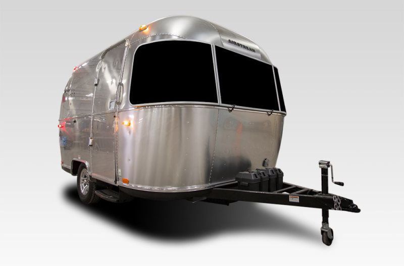 A silver airstream trailer is parked on a white background