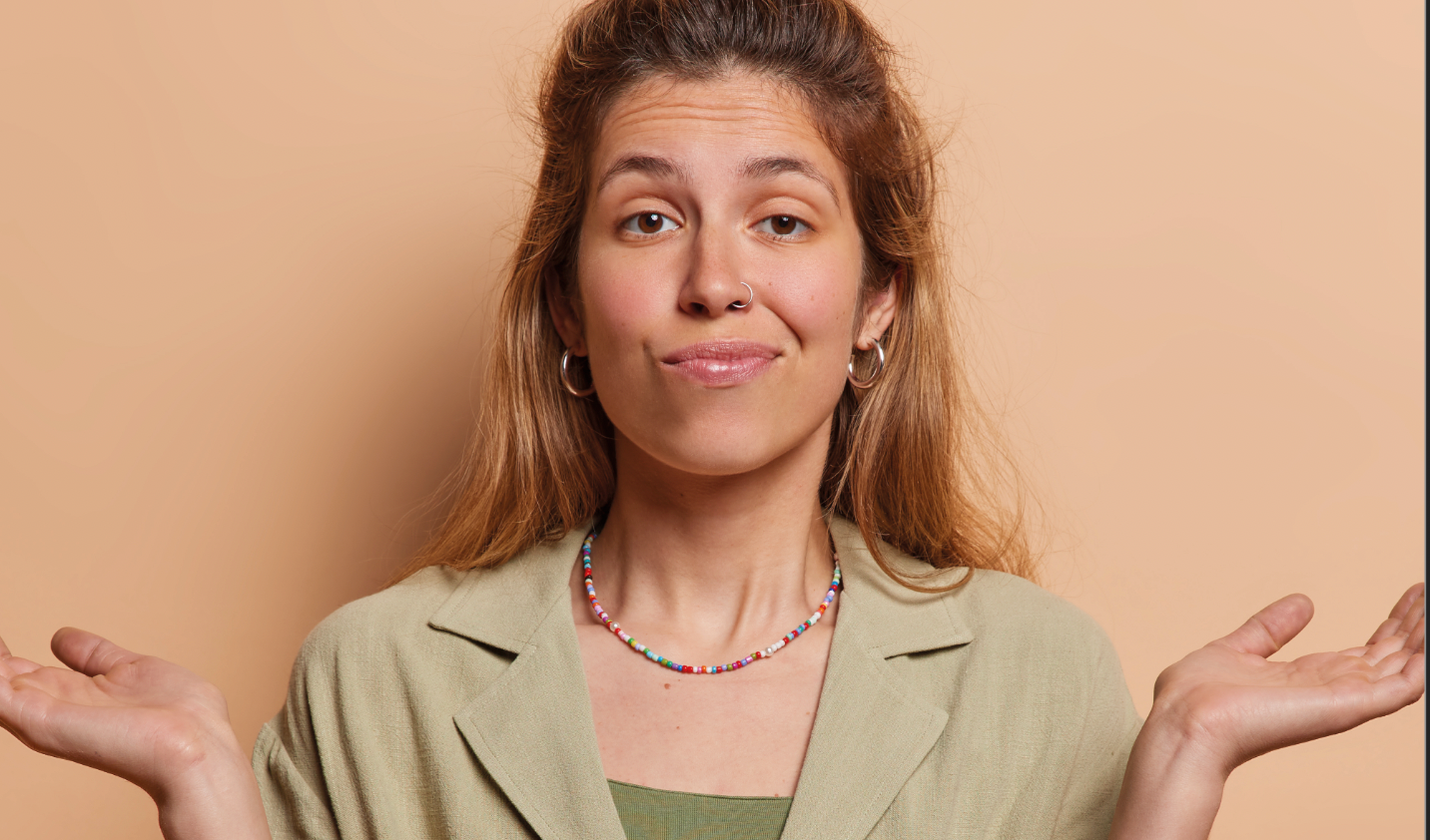 a woman wearing a necklace and earrings is shrugging her shoulders