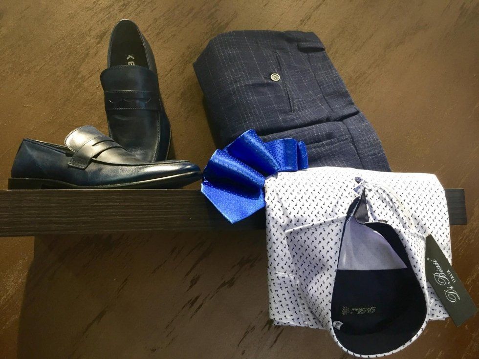 vetrina negozio con pantaloni camicie e scarpe