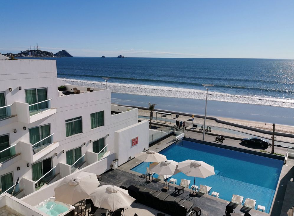 Una vista aérea de un hotel con piscina y sombrillas.