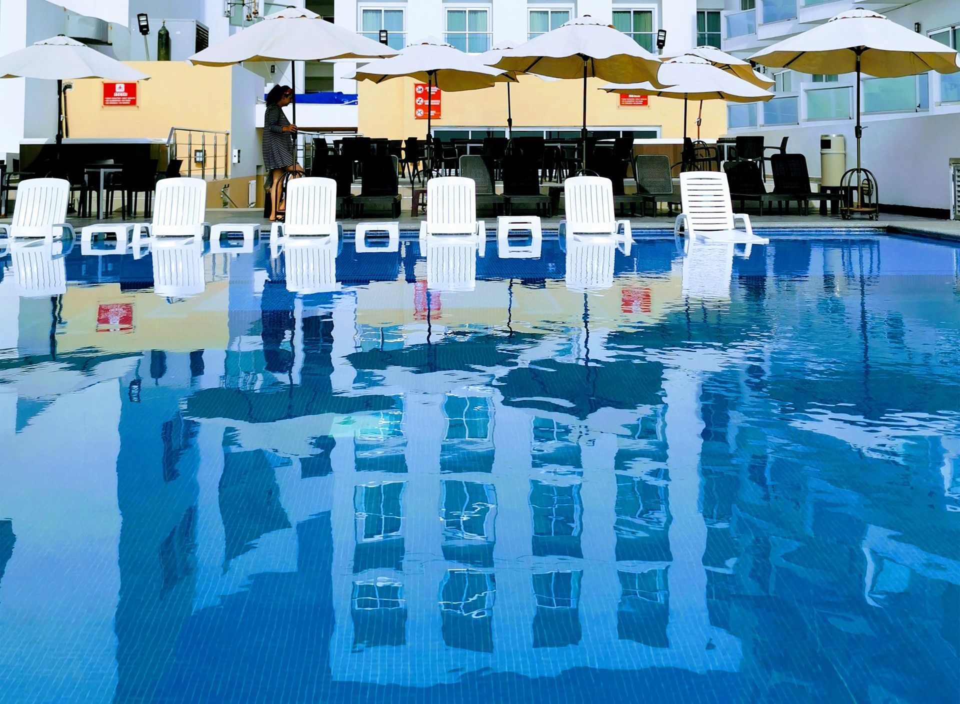 Piscina con sombrillas y sillas alrededor en hotel en mazatlan