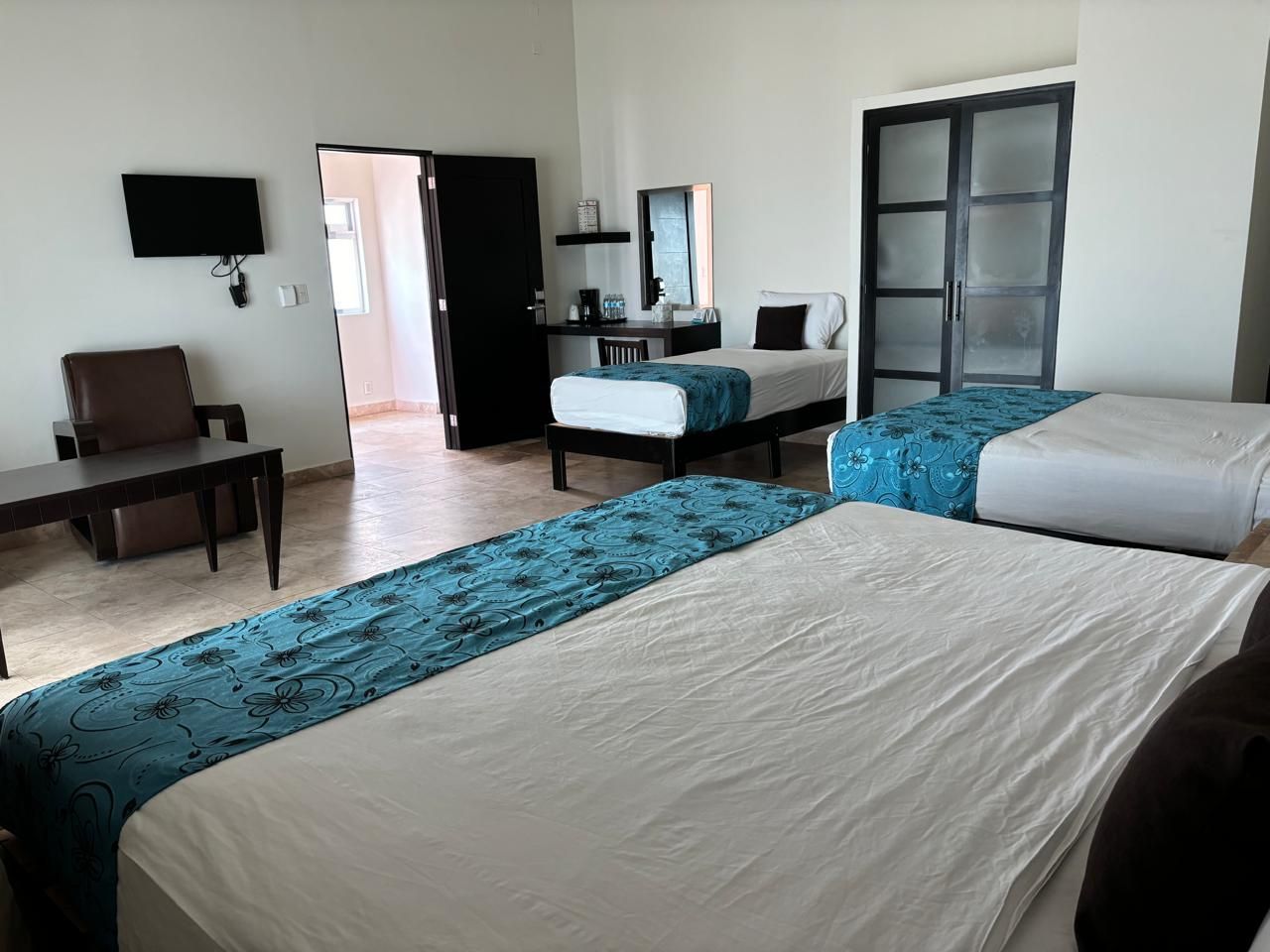 Una habitación de hotel con dos camas y una silla