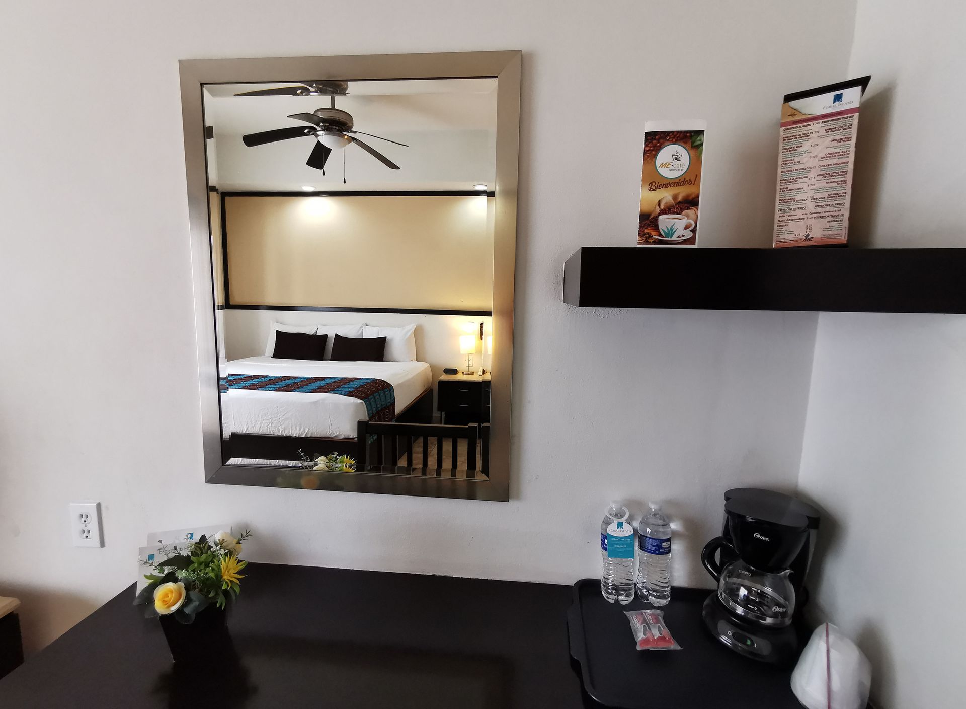 Una habitación de hotel con el reflejo de una cama en el espejo.