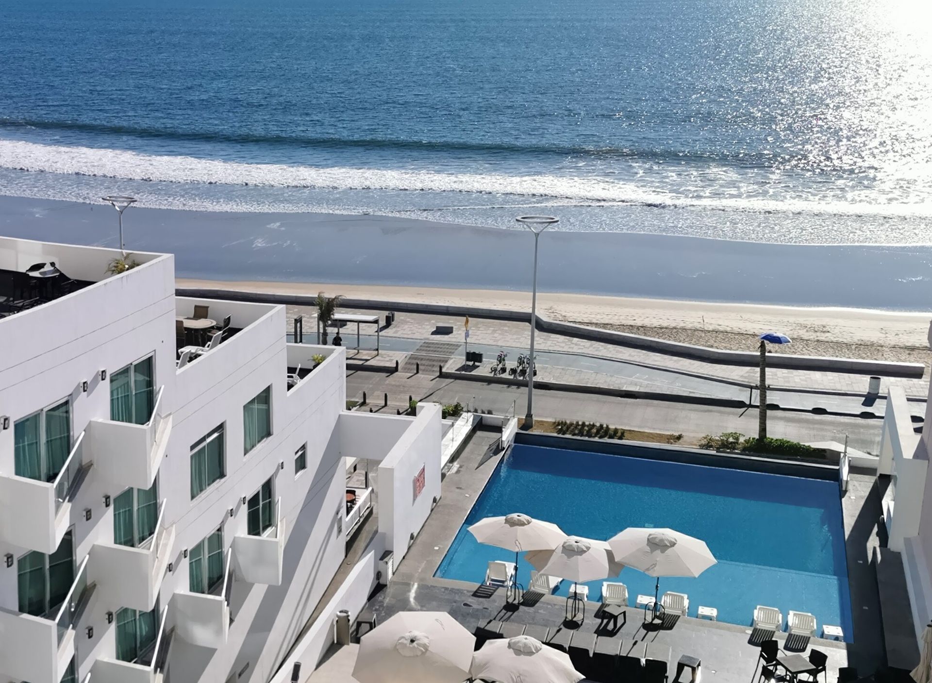 Una vista aérea de un hotel con piscina y sombrillas.