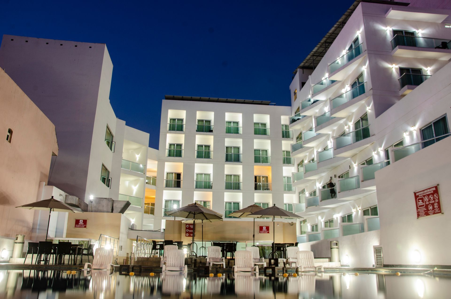 A large white building with a swimming pool in front of it
