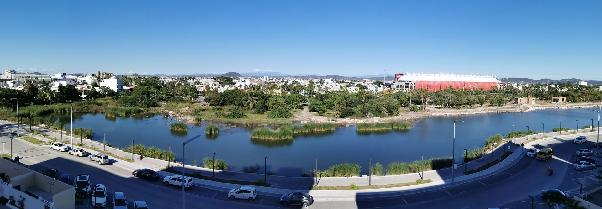 Una vista aérea de un lago rodeado de árboles y edificios.