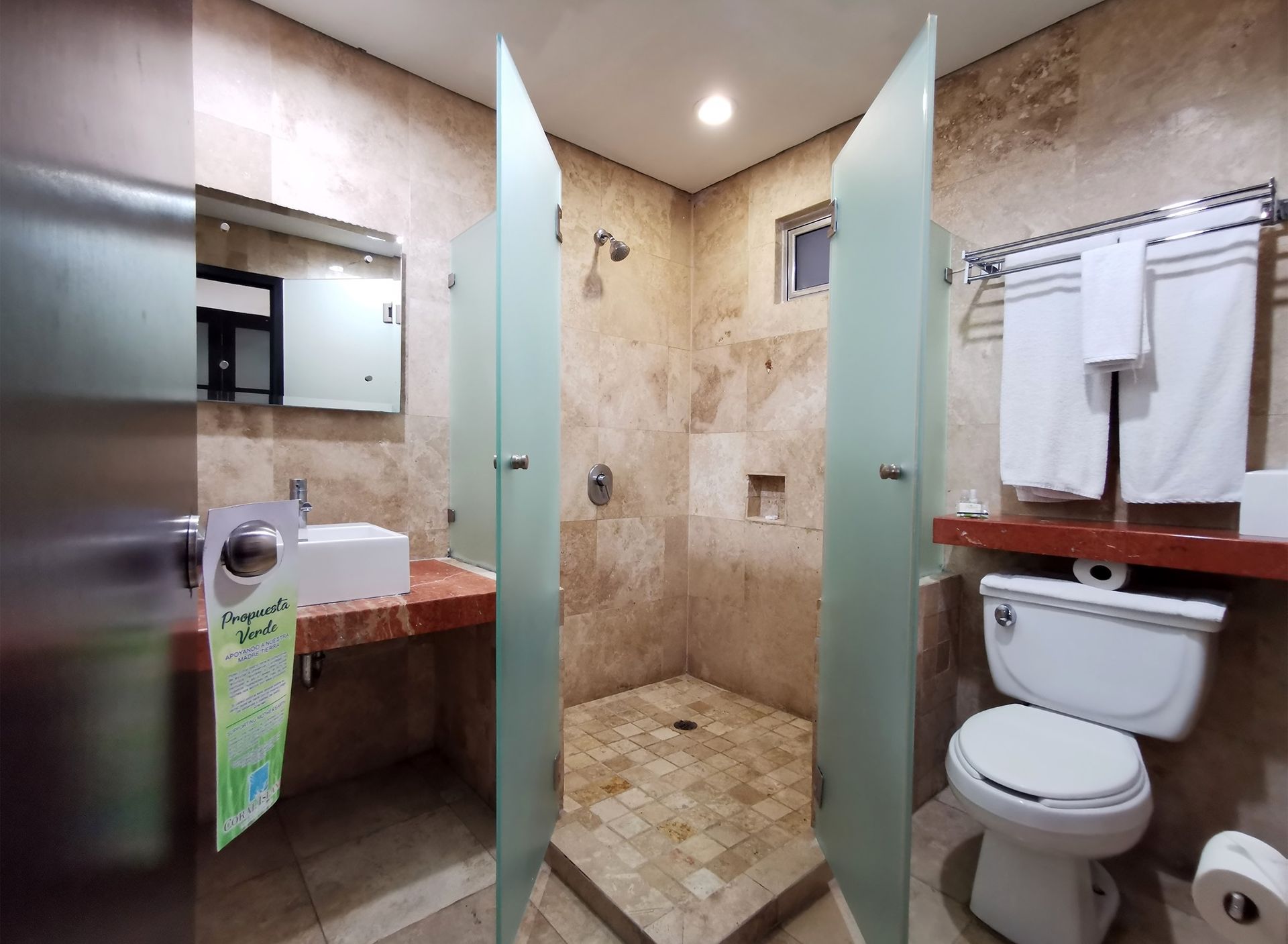 Un baño con inodoro, lavabo y ducha.