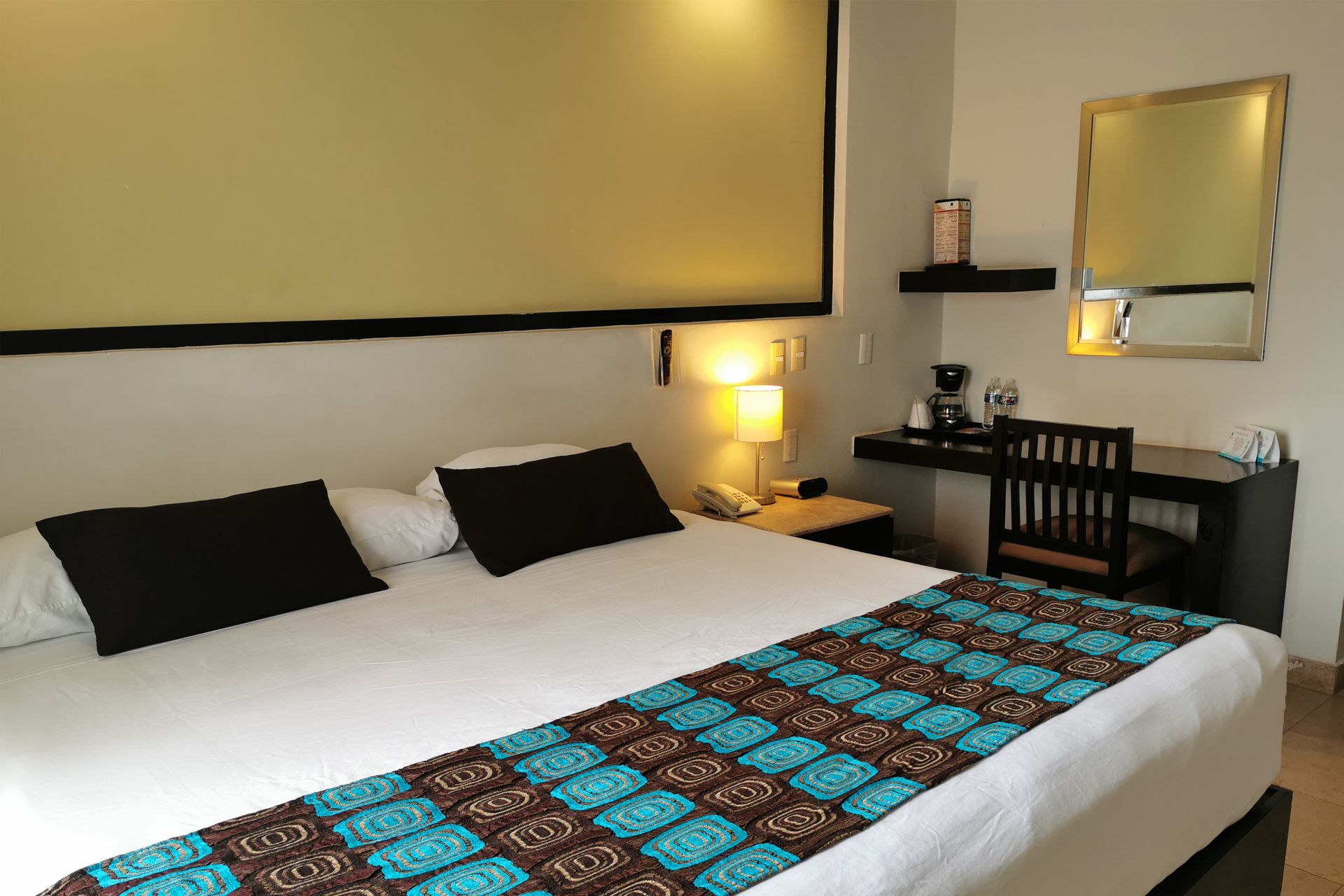 Una habitación de hotel con una cama tamaño king y un escritorio.