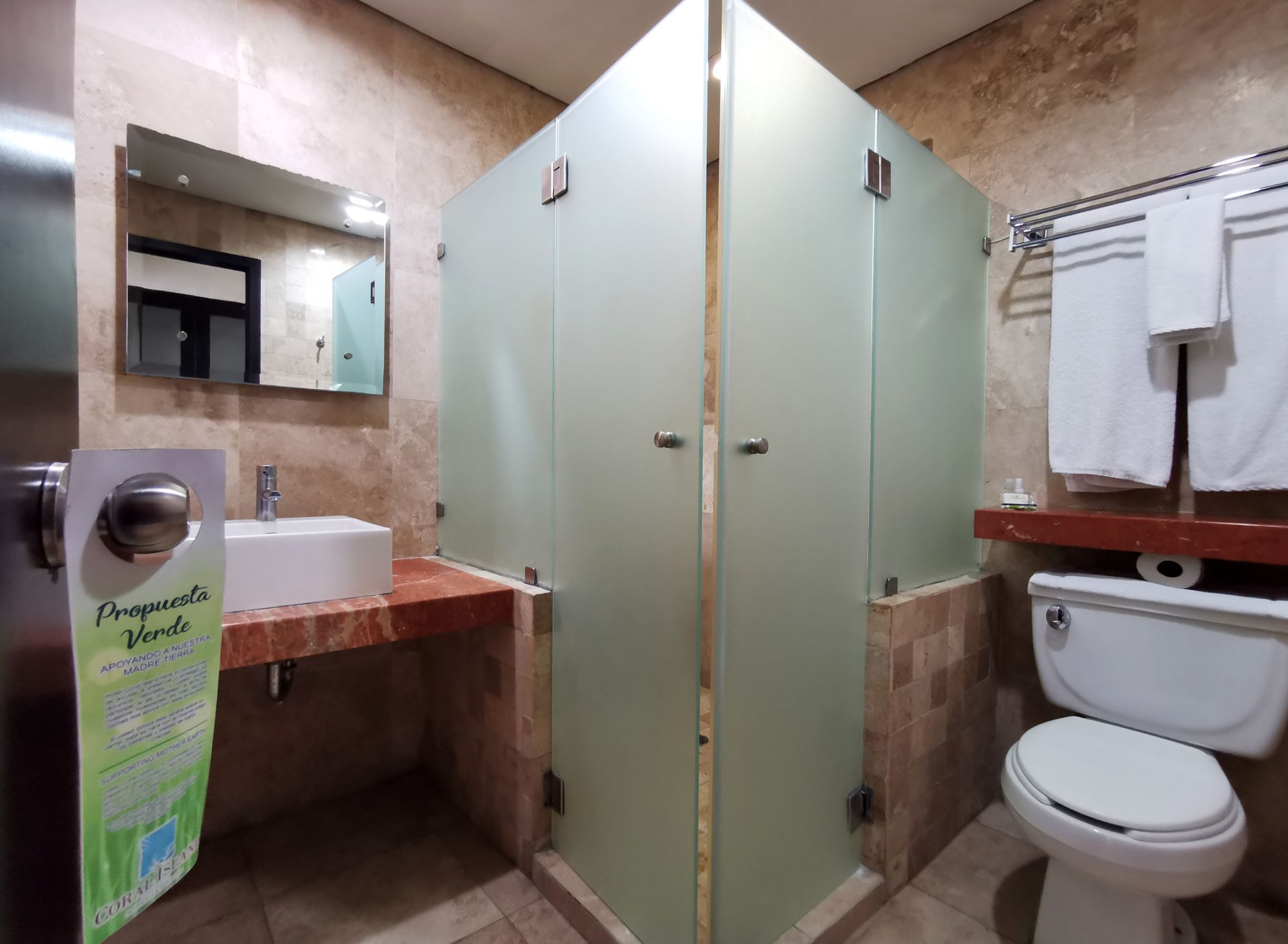 Un baño con inodoro, lavabo y ducha.