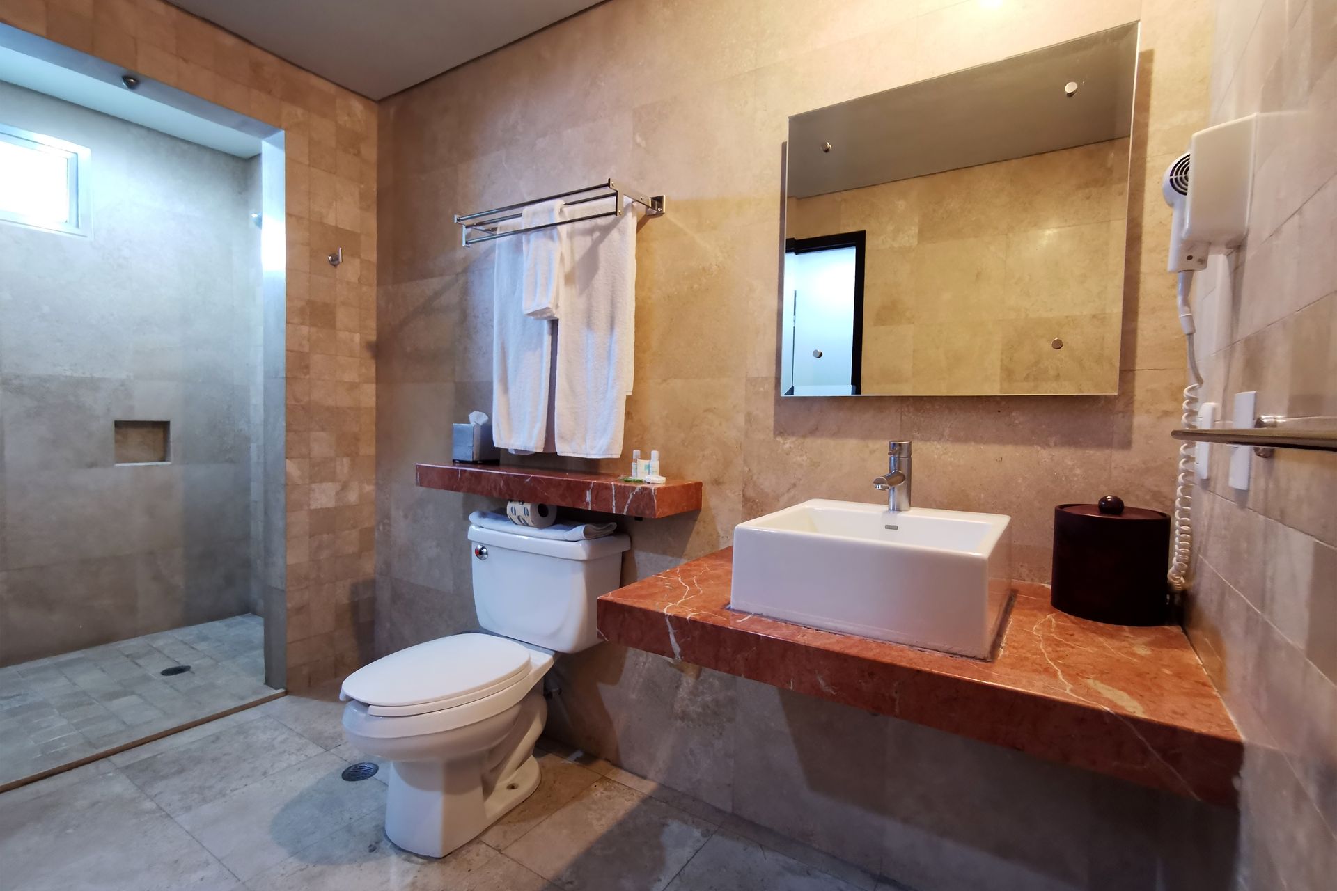 Un baño con inodoro, lavabo y espejo.