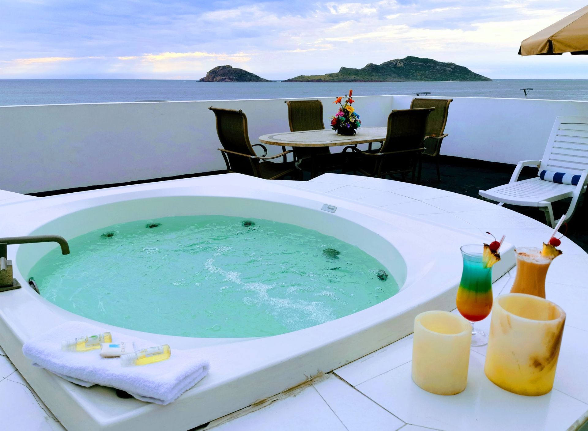 Un jacuzzi en un balcón con vista al mar.
