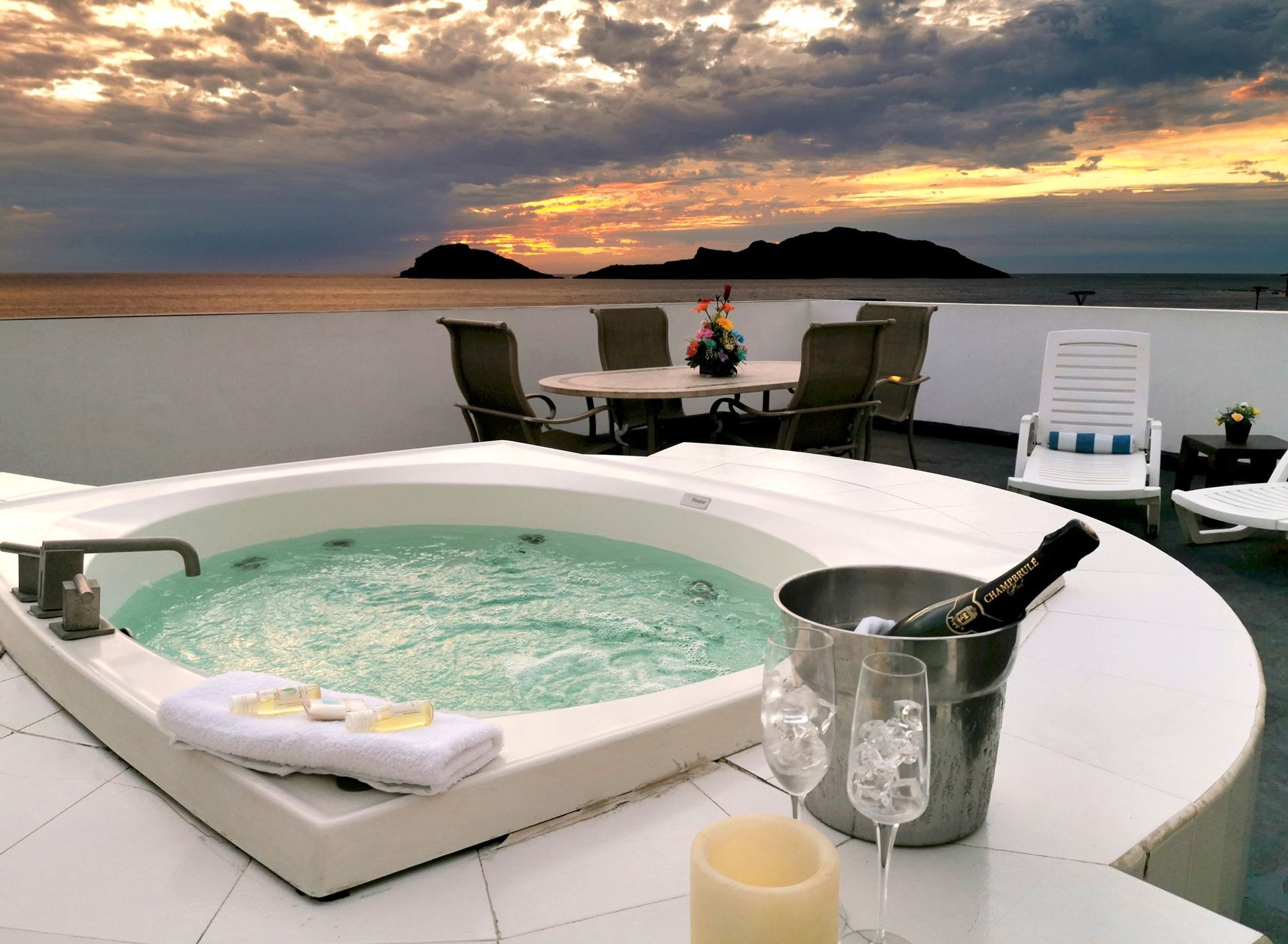 Un jacuzzi con un cubo de champán y una vela.