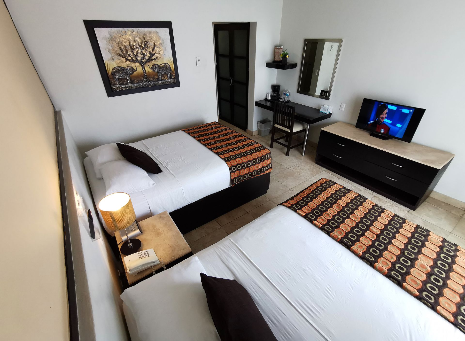 Una habitación de hotel con dos camas y un televisor.