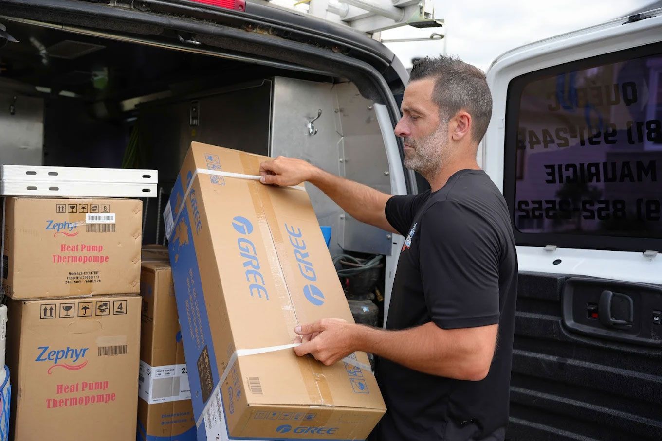 Un homme charge des cartons à l'arrière d'une camionnette.