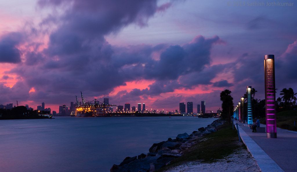 A sunset over a body of water with a city skyline in the background.