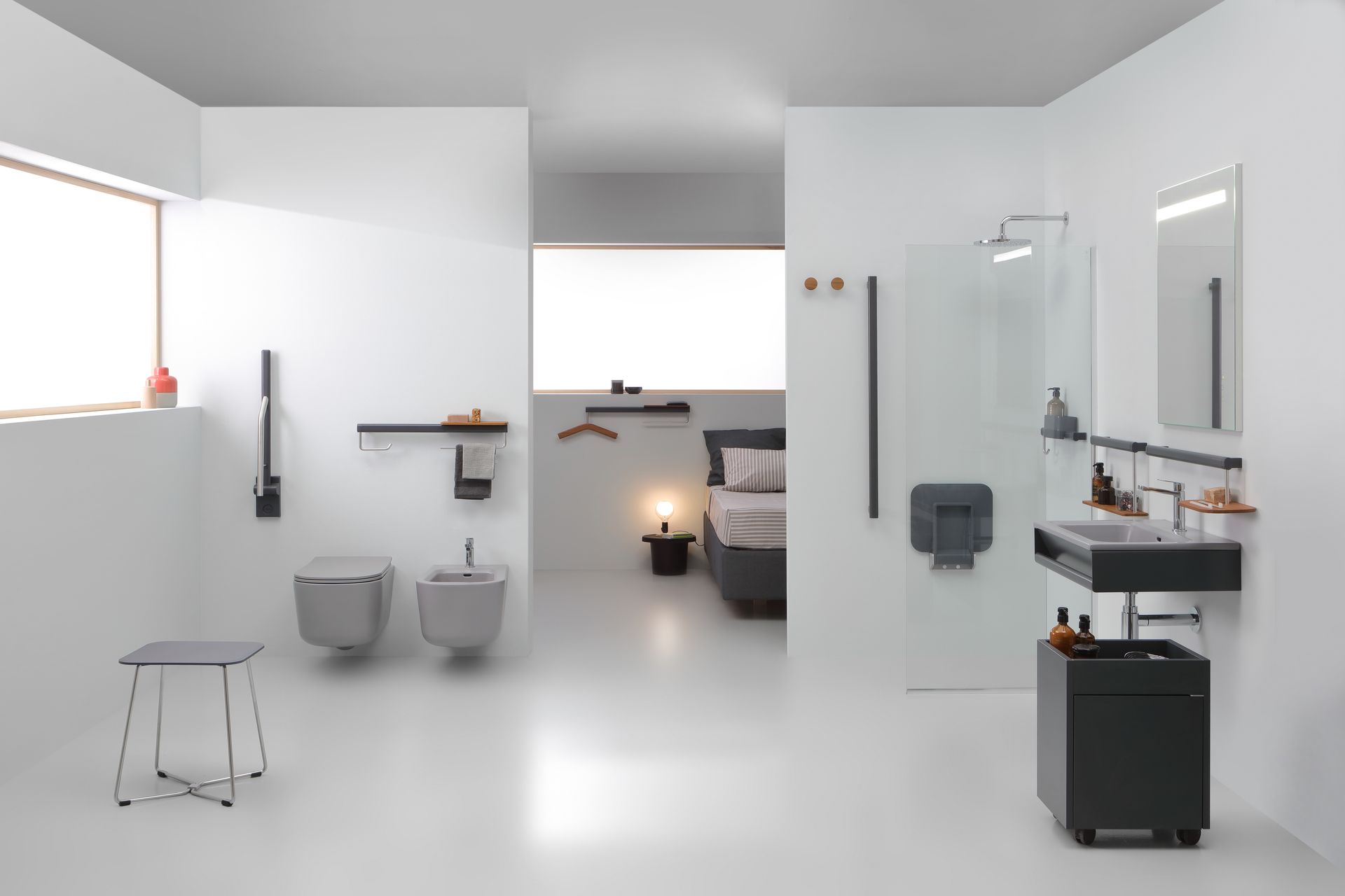 Bagno moderno e minimalista con sanitari grigi e bianchi e scorcio di una camera da letto.