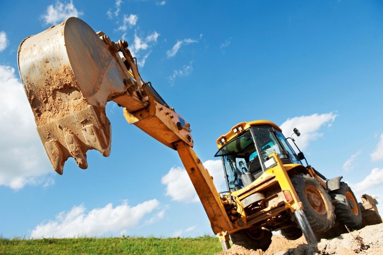 A construction vehicle digging in the dirt