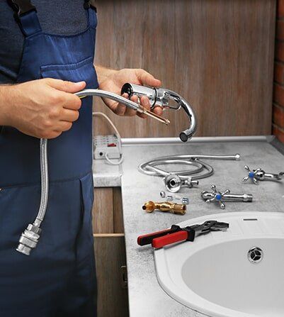 Plumber Setting Up His Tools For Sink Installation — Plumber in Allenstown, QLD