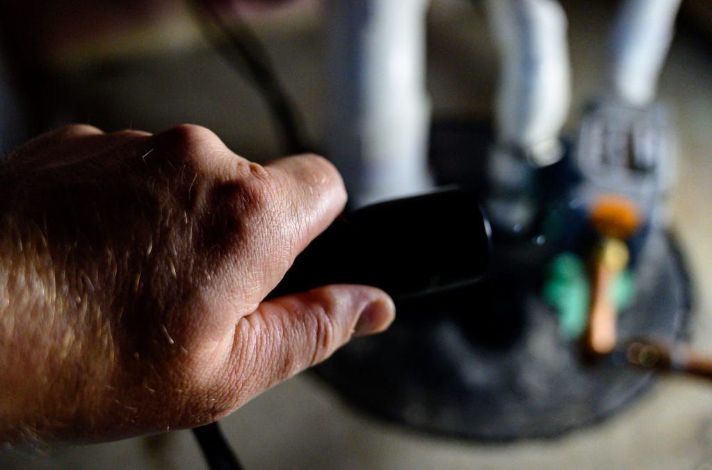 A person is holding a black object in their hand.