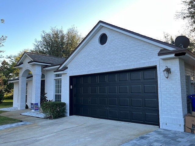 A white house with a black garage door