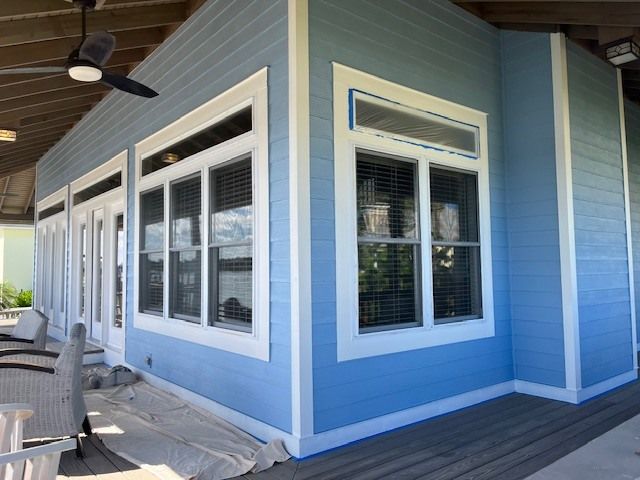 A blue house with a lot of windows and a ceiling fan