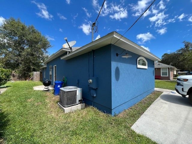A blue house with a white car parked in front of it