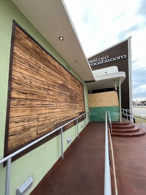 A building with a wooden wall and stairs leading up to it
