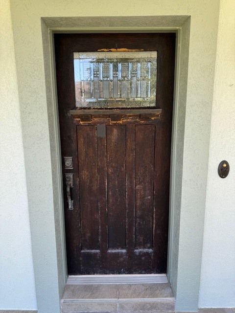 A brown wooden door with a glass window
