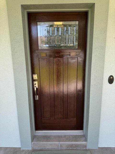 A brown wooden door with a glass window