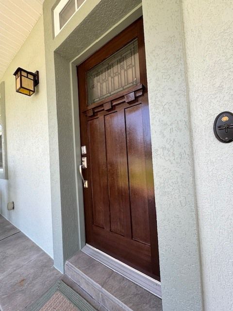 The front door of a house has a light on the wall above it