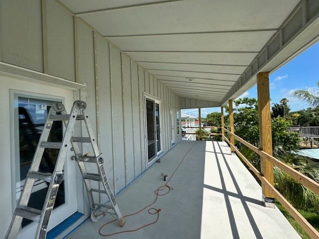 A ladder is sitting on a porch next to a window