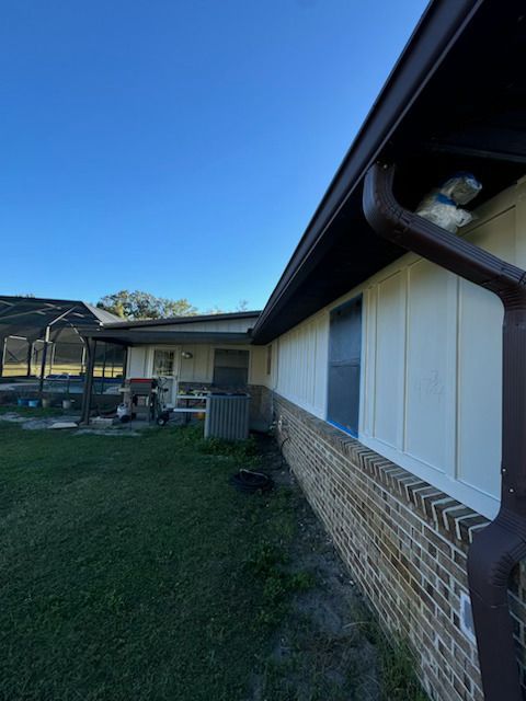 A house with a brown gutter on the side of it.