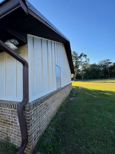 A house with a brown gutter on the side of it