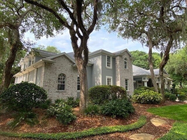 A large house with a lot of trees in front of it.