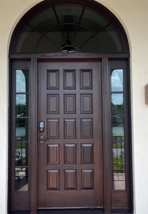 A large wooden door with arched windows and a sliding glass door