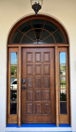 A wooden door with a lantern above it