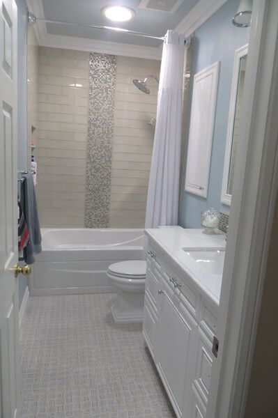 A bathroom with a tub , toilet , sink and mirror.